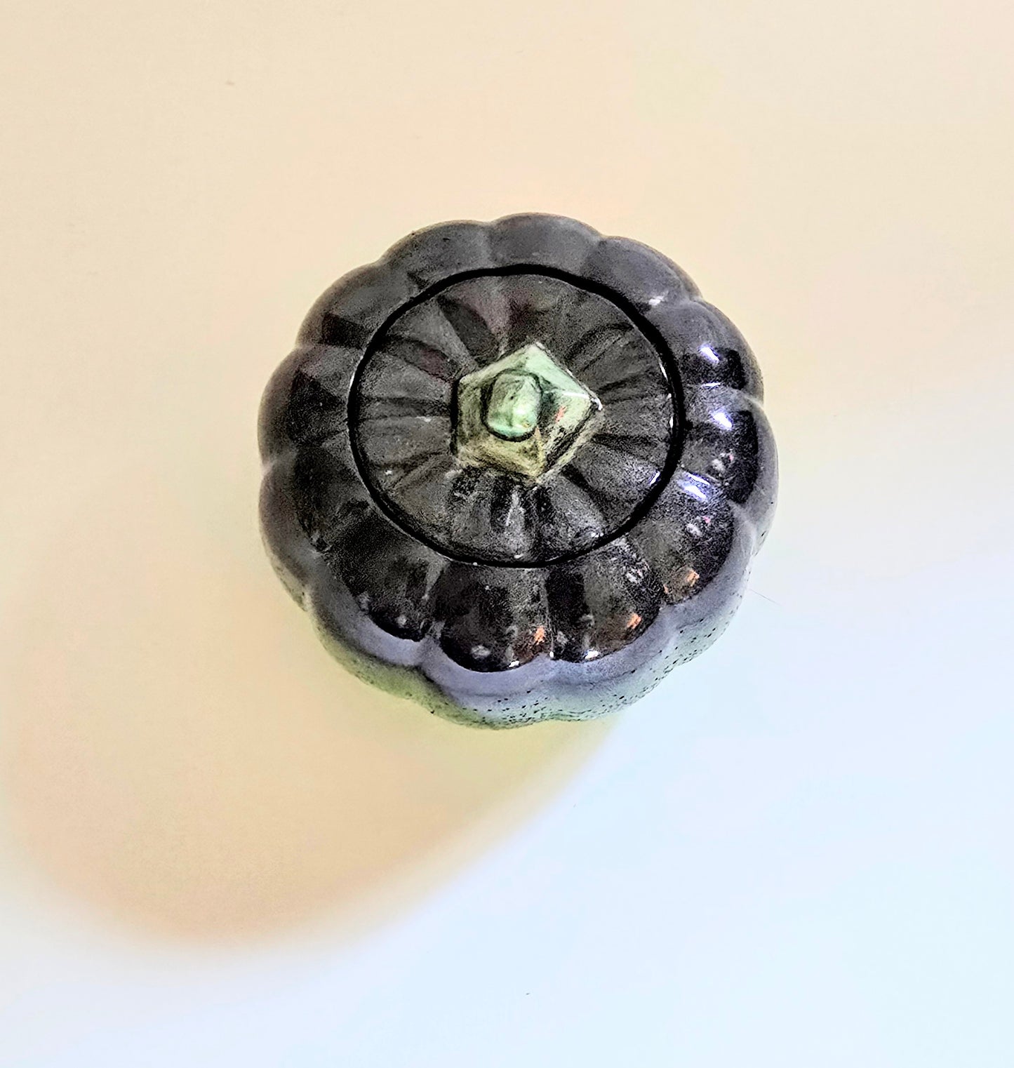 A Green And Black Resin Pumpkin.