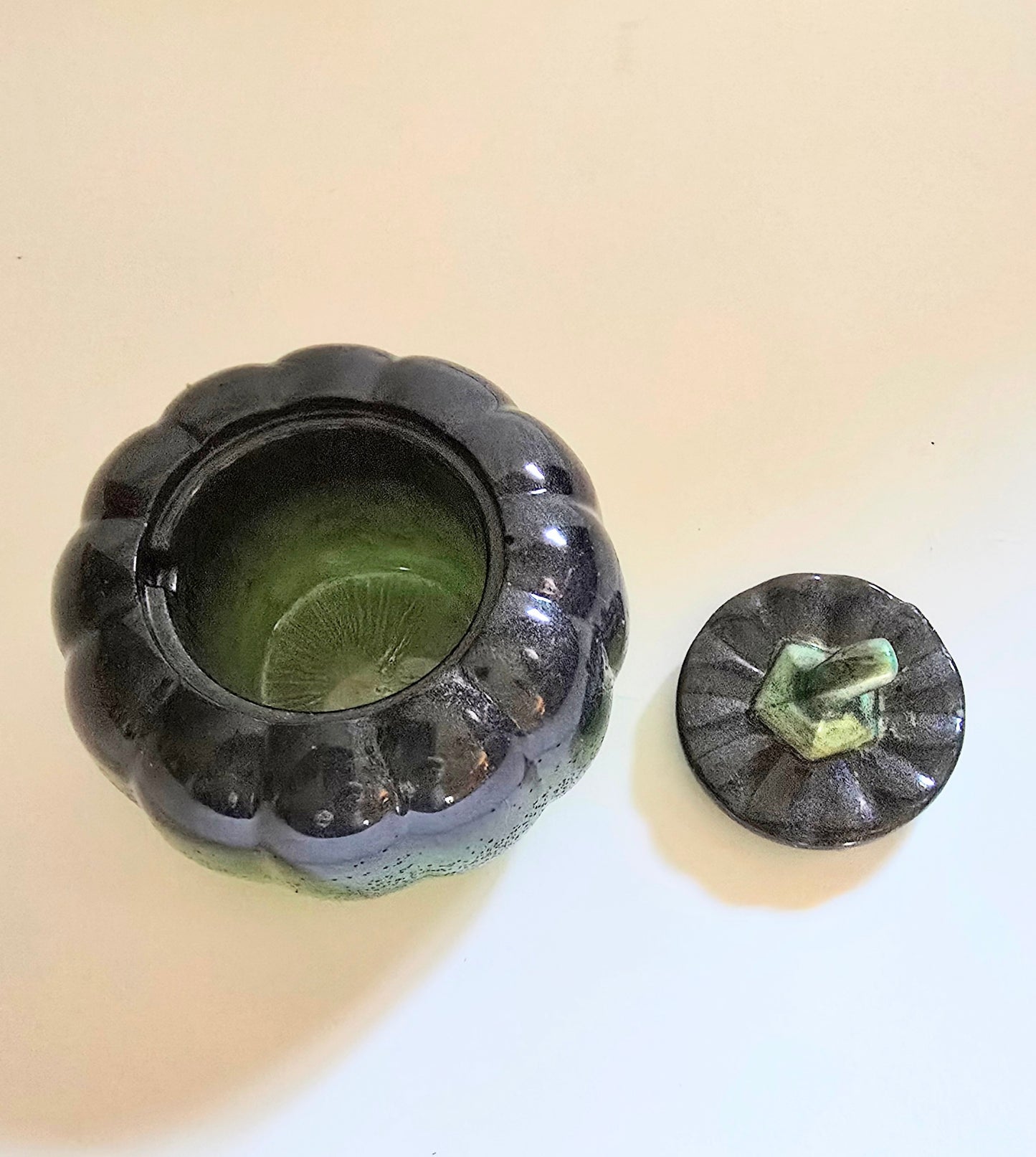 A Green And Black Resin Pumpkin.