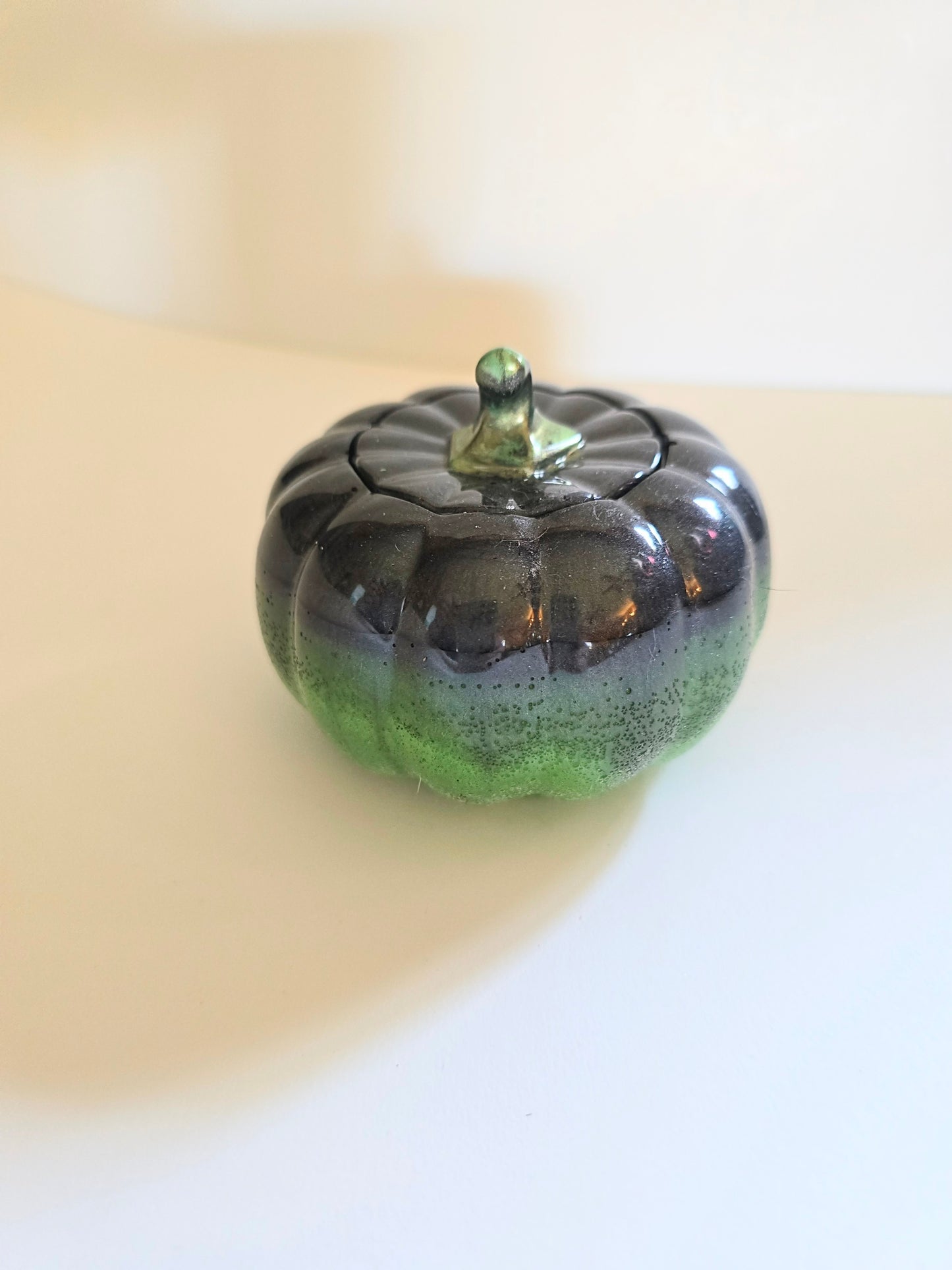 A Green And Black Resin Pumpkin.
