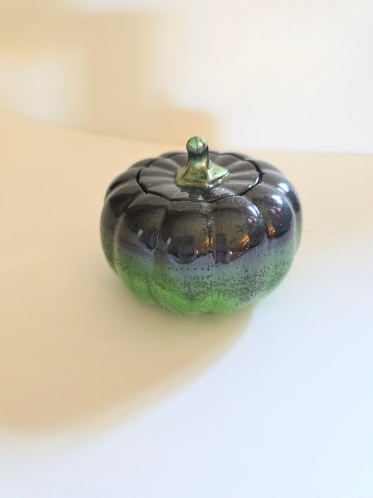 A Green And Black Resin Pumpkin.